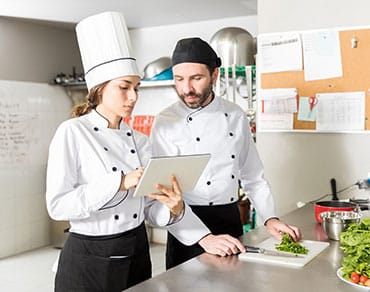 Restaurant accounting - chefs looking at tablet