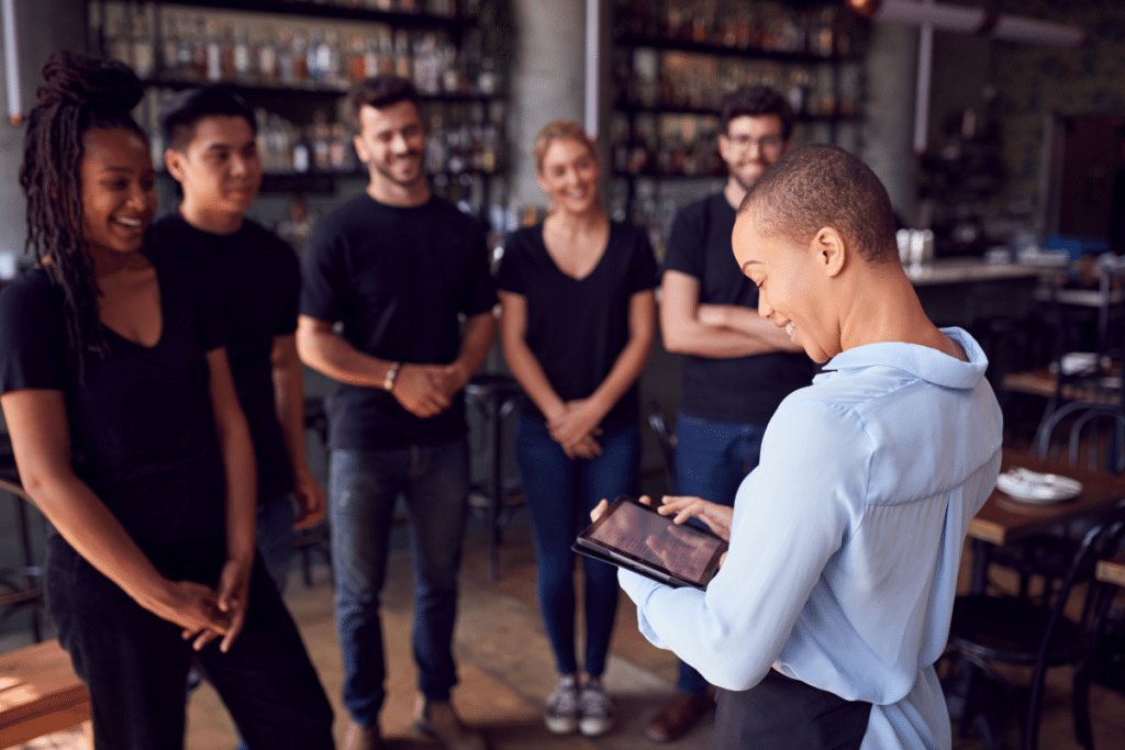 Restaurant manager having a pre-shift meeting with her team inside the restaurant