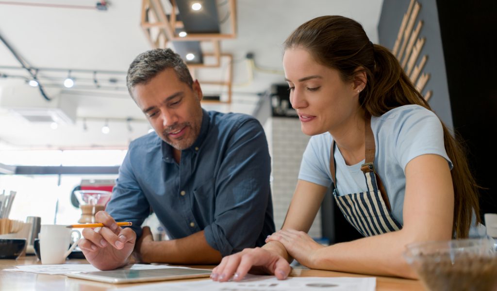 Business owners working together doing to the books at a coffee shop Restaurant Consultant Working